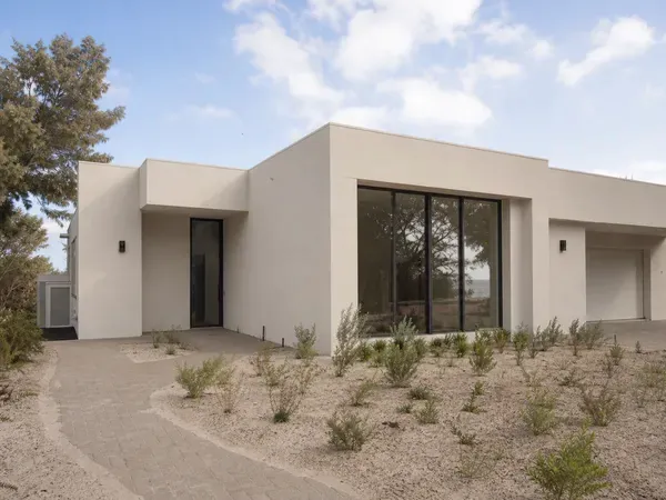 A brand-new coastal WA home at handover stage, freshly rendered with landscaping still establishing