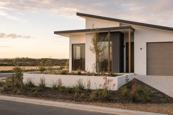 Brand-new estate home beside sand pads awaiting construction at Jindalee