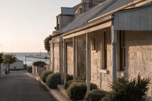 Heritage limestone cottages on a South Fremantle street sloping to South Beach