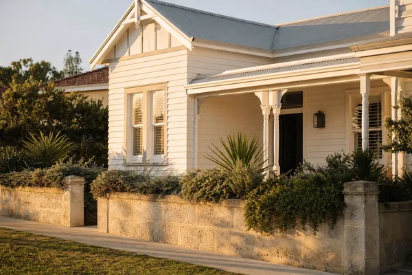 Federation weatherboard home behind a limestone wall in Swanbourne